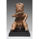 A Nayarit seated male hunchback figure Mexico, circa 100 BC - 250 AD terracotta, wearing a head band