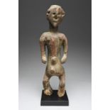 A Montol standing male figure Nigeria with a flat disc coiffure and an elongated face, with flat