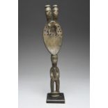 An Urhobo rattle Nigeria with a standing male handle with a flat part pierced blade with stylised