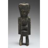 An Igbo male shrine figure Nigeria with a raised boss to the top of the head and a chest pocket
