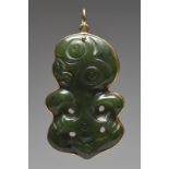 A hei-tiki pendant nephrite with a gold mount and suspension loop, 5.4cm high, on a stand. (2)