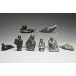 A collection of eight Inuit stone carvings including a seated figure holding a seal, signed LYDIA