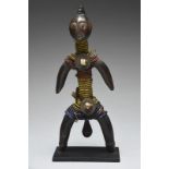 A Namji doll Cameroon with a crested coiffure and open mouth with coloured glass bead and fibre
