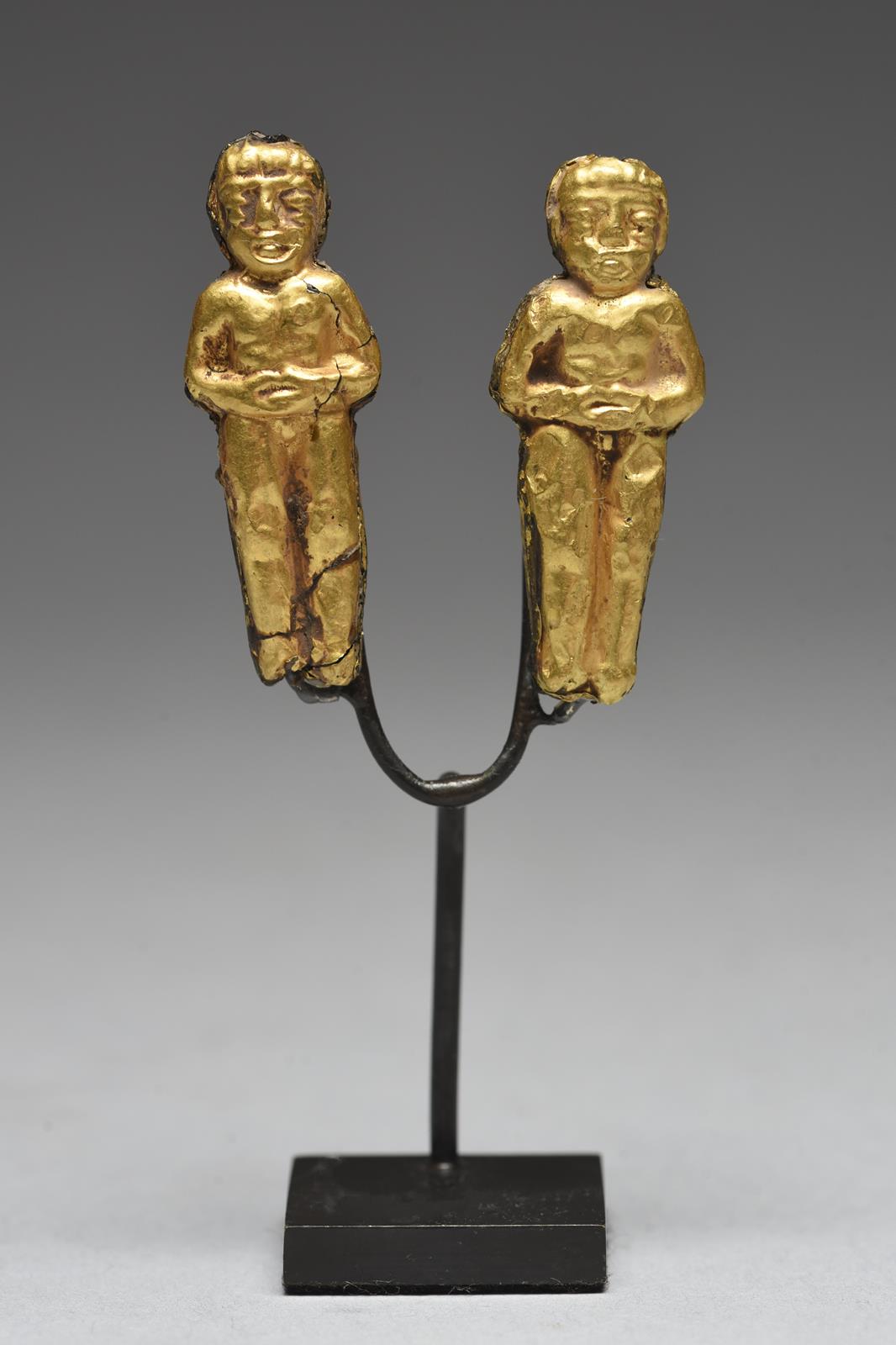 Two Chimu figural pendants Peru resin with gold leaf, one janus and all with hands folded onto the