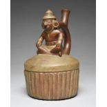 A Moche stirrup spout vessel Peru, circa 400 - 700 AD of circular ribbed form with a domed top