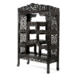 A CHINESE CARVED HARDWOOD DISPLAY CABINET 19TH CENTURY of stepped form, with carved and pierced