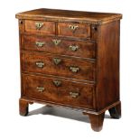 A GEORGE I WALNUT BACHELOR'S CHEST C.1720 with feather and crossbanding, the quarter veneered hinged