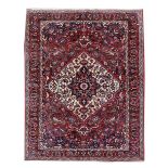 A BAKHTIARI CARPET WEST PERSIA, C.1970 with a raspberry field of flowering vines around an ivory and