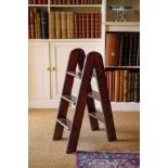 A SET OF MAHOGANY FOLDING LIBRARY STEPS EARLY 20TH CENTURY with three treads, the inner edge stamped