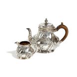 A SMALL VICTORIAN SILVER TEAPOT AND CREAM JUG BY FREDERICK BRASTED, LONDON, 1885 of baluster from,