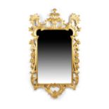 A GILTWOOD WALL MIRROR IN GEORGE II STYLE, 19TH CENTURY the shaped plate within a frame carved