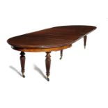 A VICTORIAN MAHOGANY DINING TABLE C.1870-80 the top with a reeded edge with rounded ends extending