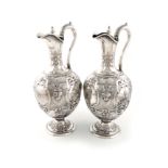 λA pair of Victorian silver ewers, by Martin, Hall and Co., Sheffield 1856, baluster form,