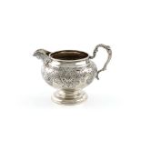 A George IV silver cream jug, by John Baddeley, London 1820, circular bellied form, foliate capped