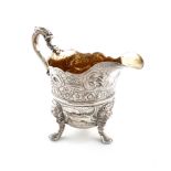 A George III Irish silver cream jug, by John Hamilton, Dublin circa 1740, helmet form, leaf capped