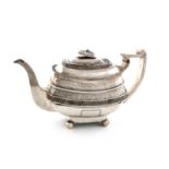 A George III silver tea pot, marks worn, London 1813, rounded oblong form, chased foliate and scroll