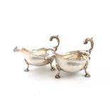 A pair of George II silver sauce boats, by George Baskerville, London 1750, oval form, wavy-edge