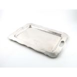 A South American metalware two-handled tray, by A. Venegas, Venezuela, of shaped rectangular form,