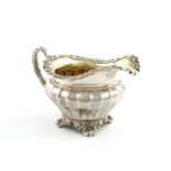 A George III silver cream jug, by Paul Storr, London 1819, fluted tapering circular form,