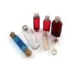 A collection of seven scent bottles, comprising: a silver-mounted red glass bottle, by Levi and