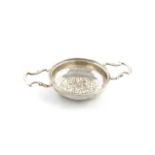 A George III two-handled silver lemon strainer, by Edward Aldridge, London 1765, circular form, with