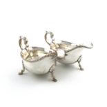 A pair of silver sauce boats, by Thomas Bradbury and Son, Sheffield 1928/29, oval form, scroll