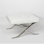 A modern chrome metal Barcelona Ottoman foot stool after a design by Mies van der Rohe, with white
