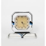 An Art Deco enamelled glass desk clock, on rectangular base, the octagonal face enamelled with