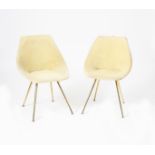 A pair of Italian chairs, brass flaring legs supporting bucket seat with plush cream upholstery,
