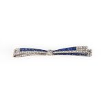 An Art Deco sapphire and diamond bow brooch, the stylised bow millegrain-set with French-cut