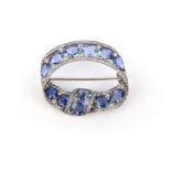 A sapphire and diamond brooch, Russia, early 20th century, designed as a looped ribbon, set with