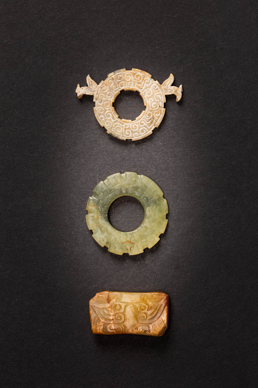 THREE CHINESE ARCHAIC JADE ORNAMENTS WESTERN ZHOU AND EASTERN ZHOU DYNASTY Comprising: a flat opaque