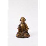 A CHINESE GILT-BRONZE FIGURE OF VAJRAPUTRA 17TH/18TH CENTURY The luohan seated in dhyanasana, with