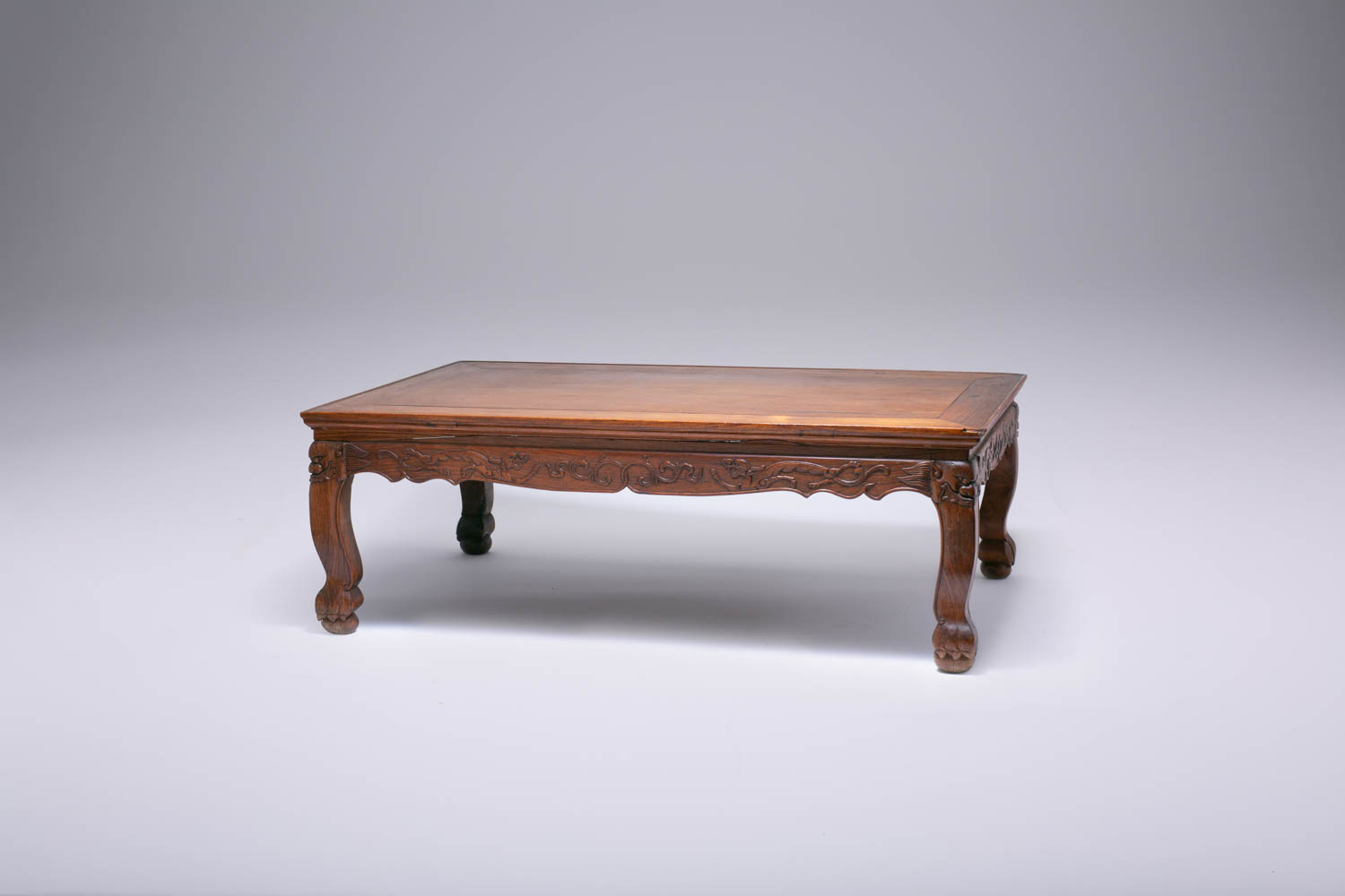 A CHINESE HUANGHUALI KANG TABLE QING DYNASTY The rectangular top above a shaped frieze carved in