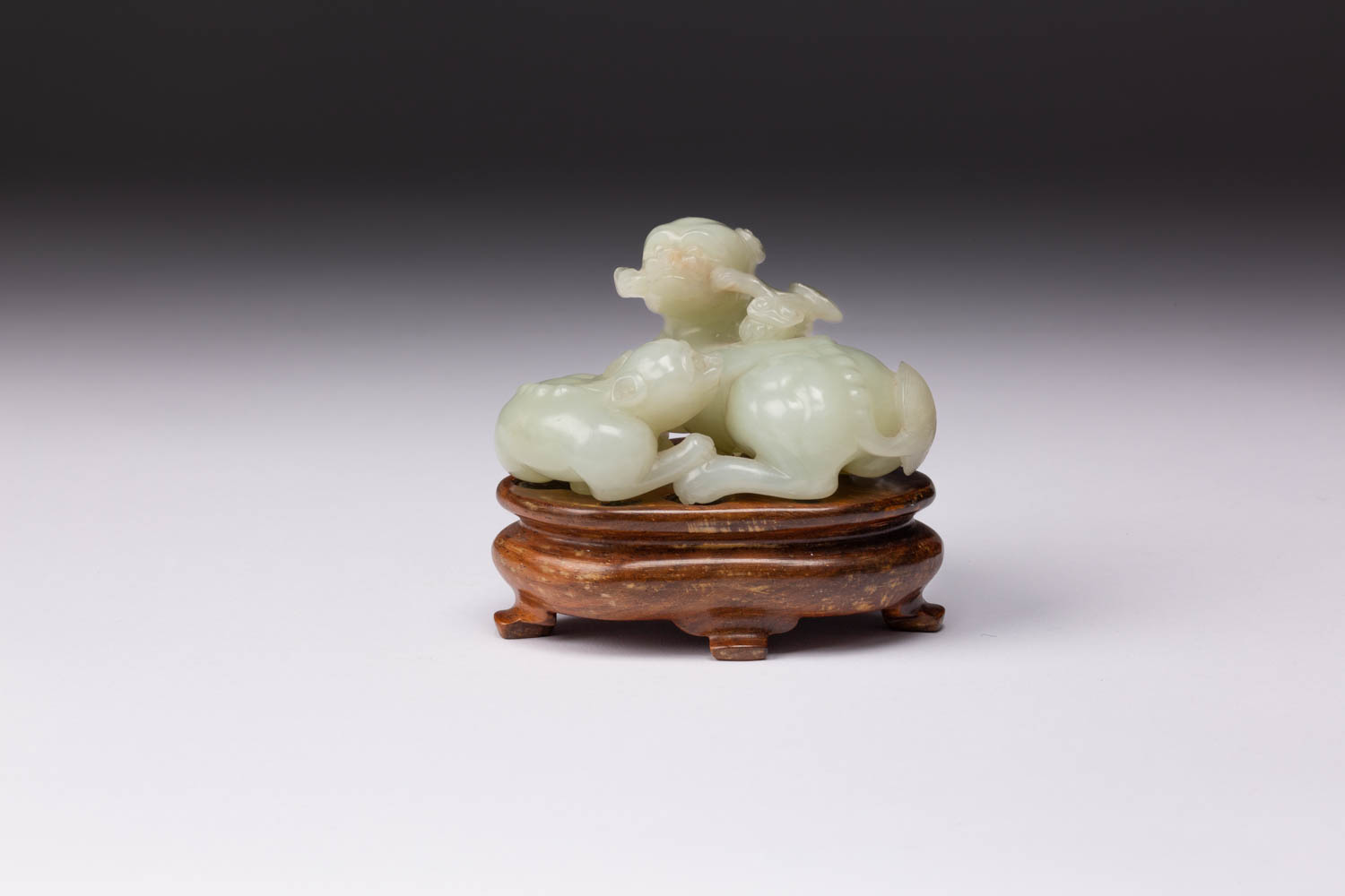A CHINESE PALE CELADON JADE LION DOG GROUP 19TH CENTURY Carved as a recumbent mother and pup, both