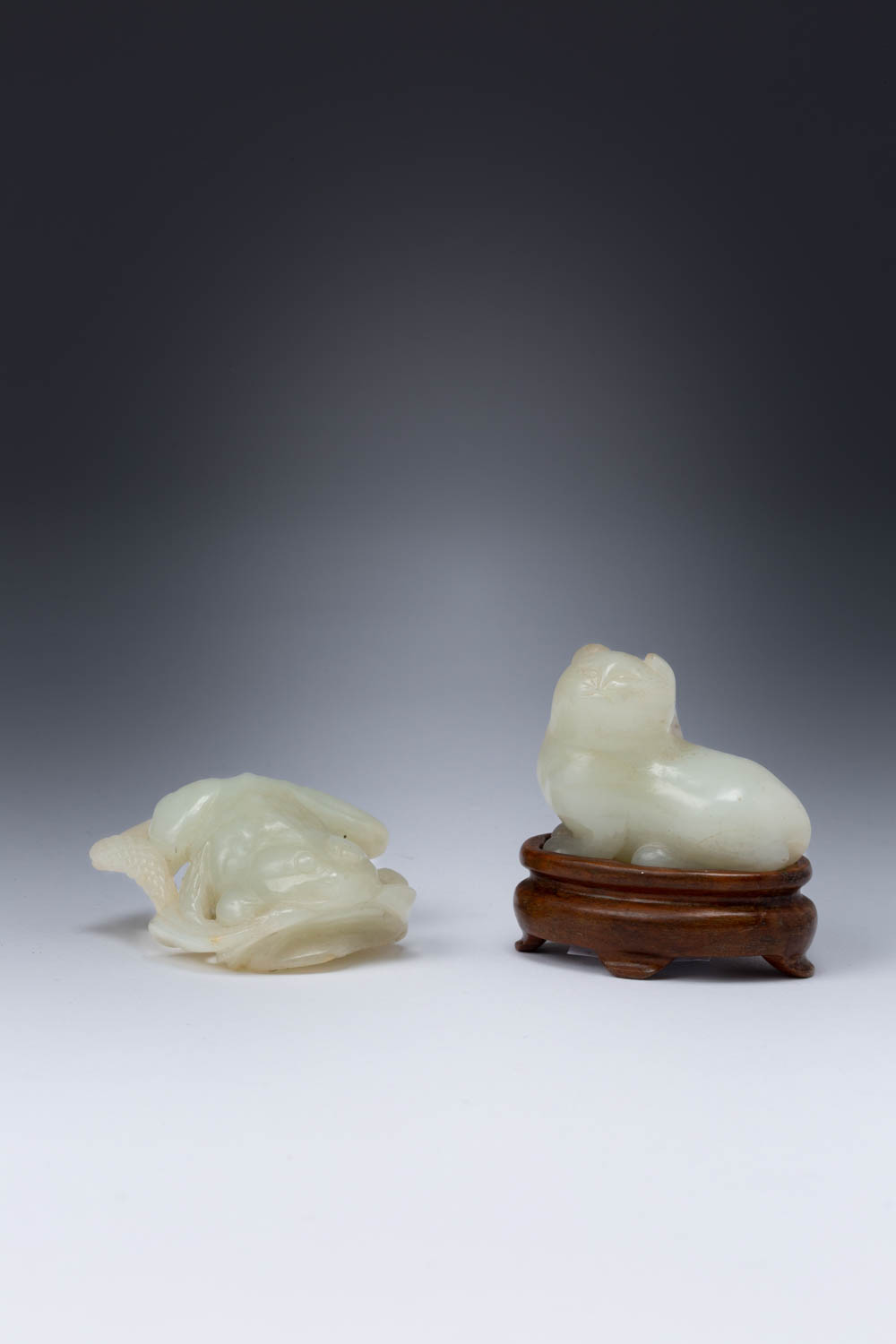 TWO CHINESE PALE CELADON JADE CARVINGS OF ANIMALS QING DYNASTY One a recumbent cat with its head