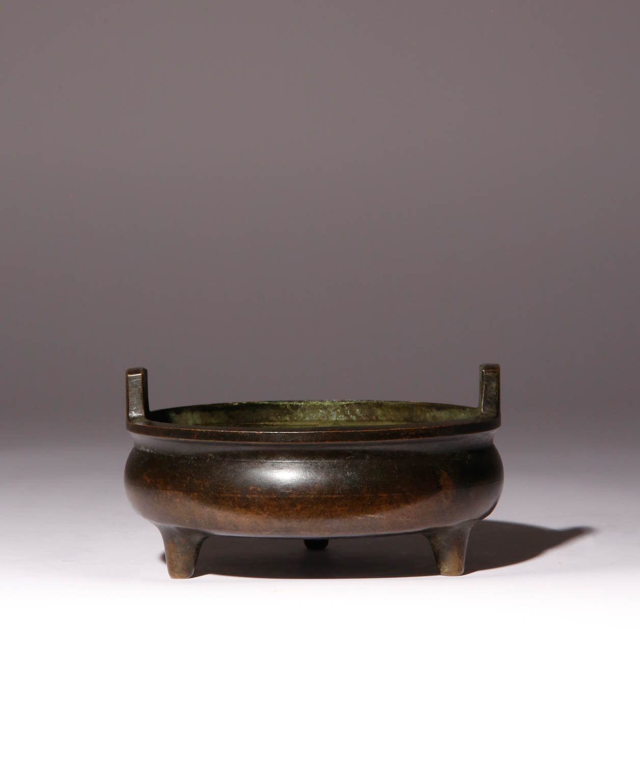 A CHINESE BRONZE TRIPOD INCENSE BURNER QING DYNASTY OR LATER The circular rounded body with two
