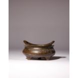 A CHINESE BRONZE INCENSE BURNER QING DYNASTY The compressed circular body with two flaring loop