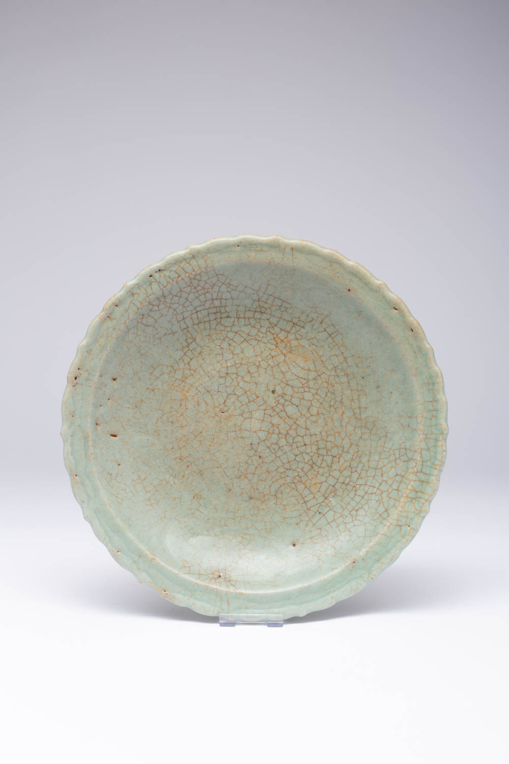 A CHINESE CELADON DISH BARBED-RIM CHARGER 16TH/17TH CENTURY The shallow flaring sides rising from