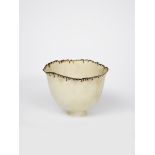 Mary Rogers (born 1929) a porcelain vase on narrow foot, with irregular split top rim, matt white,