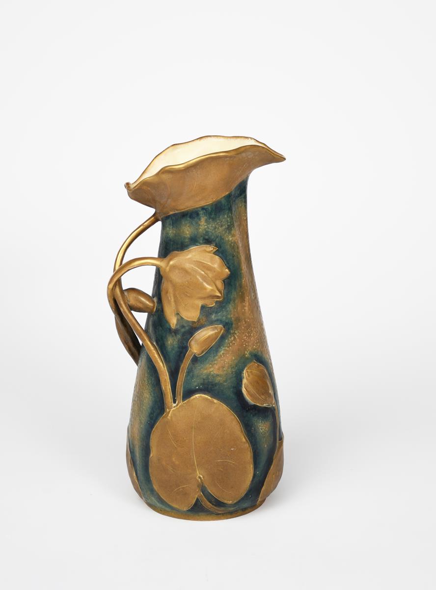 An Art Nouveau Amphora Pottery jug, model no.8860, moulded in relief with water lily flowers and pad