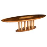 A large contemporary burr walnut and beech table, oval base with twelve birch cylindrical legs,