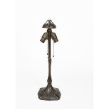 A Handel patinated metal lamp base, the flaring square section base cast in low relief with