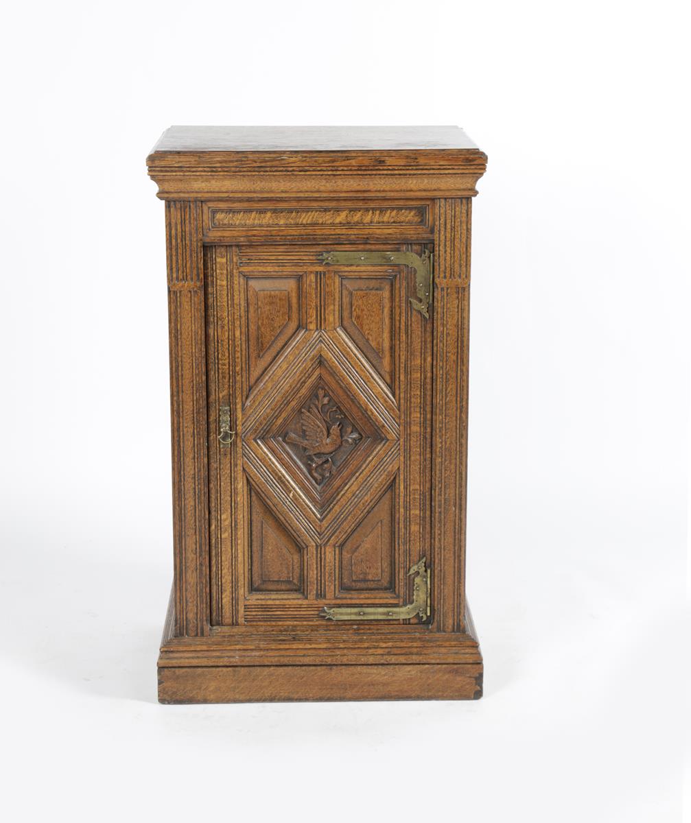 An Aesthetic Movement bedside cabinet, rectangular section, the hinged, panelled door with carved