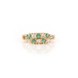 An emerald and diamond ring, set with two rows of circular-cut emeralds and diamonds arranged in
