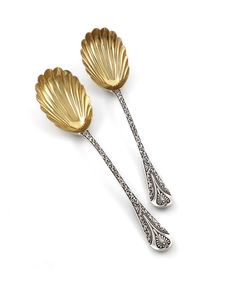 A pair of Victorian silver Newton pattern fruit serving spoons, by George Adams, London 1874, gilded