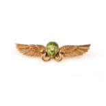 A gold and peridot brooch, late 19th century, collet-set with a pear-shaped peridot, within an