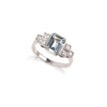 An aquamarine and diamond ring, the step-cut aquamarine set within diamond-set shoulders in