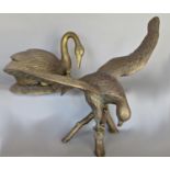 A brass golden eagle perched on a branch, 39 cm high and a brass swan tending cygnet and eggs, 33 cm