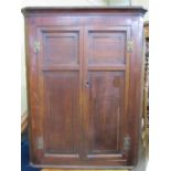 A Georgian oak hanging corner cupboard with barrel back and simply fitted interior, 80 cm wide x